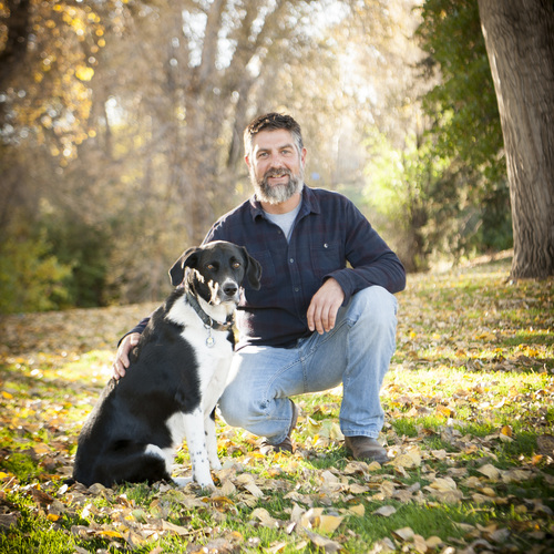 Jason Olejniczak in a field with his dog